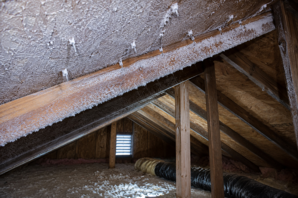 Frost buildup on attic roof sheathing during winter caused by warm indoor air reaching a cold attic space